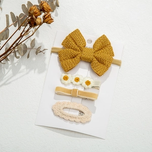 Close-up of a 4-piece set of knitted hair clips and headbands on a display card