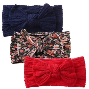 Three-piece baby headband set with large bows in navy, floral, and solid red colors