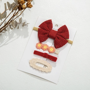 Detail of 4-piece red hair accessory set with knits, bows and floral clips for girls