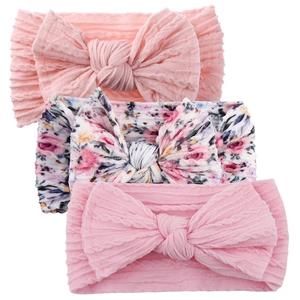 Detailed macro view of 3-piece baby headbands with pink and floral bow knit textures