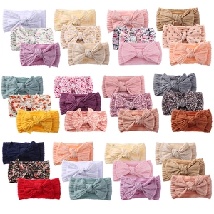 24-pack of soft nylon baby headbands with assorted prints and layered bows for infants