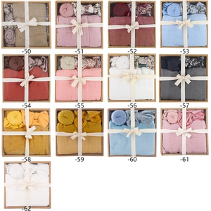 Grid view of newborn swaddle sets in thirteen colors including hats and headbands