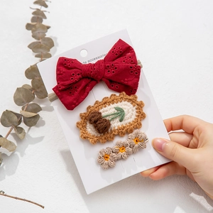 Detailed set of three handcrafted knit floral hair clips and red lace bow headband