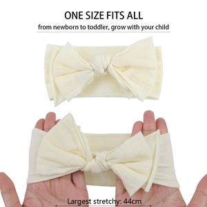Elastic beige baby headband with large bow showing 44cm maximum stretch for all sizes