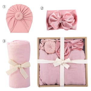 Pink newborn baby swaddle blanket with matching knot hat and velvet bow headband gift set