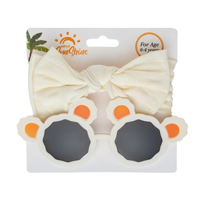 Detail of baby bow headband and panda bear sunglasses set on packaging for ages 0-4