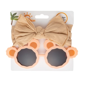 Detail view of baby bow headband and cute bear-ear sunglasses set on white packaging