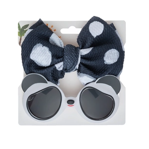 Close-up of baby panda sunglasses and polka dot bow headband set on a display card
