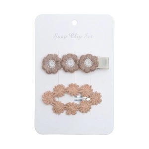 Detail view of two-piece embroidered daisy hair clips for kids on a card