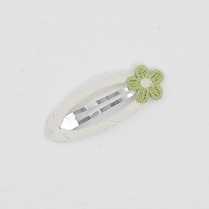 Detail von Baby-Haarspange mit cremeweißem Stoffbezug und grün bestickter Gänseblümchenblume