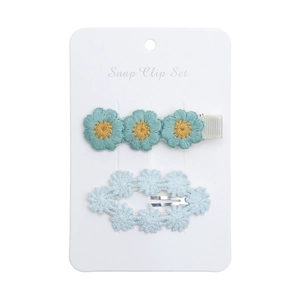 Detailed view of handmade daisy embroidery and lace snap clips for toddlers