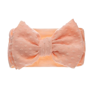 Détail du bandeau bébé orange-rose avec nœud papillon et motif jacquard à pois