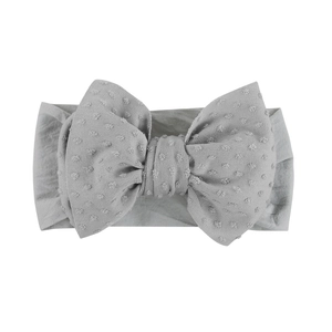 Vue détaillée d'un bandeau gris pour bébé en tissu jacquard doux avec un grand nœud élégant