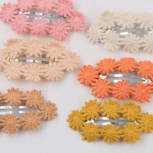 Details von bunten Häkelblumen-Haarspangen in Rosa, Beige und warmen Farbtönen