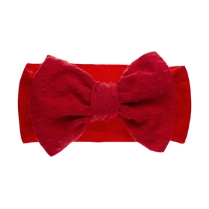 Détail d'un bandeau bébé en nylon rouge avec un nœud jacquard à pois en relief