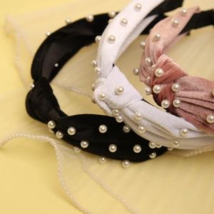 Detail of velvet twisted headbands with white pearl beads in black, white and pink