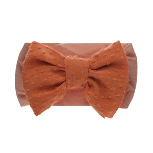 Détail du nœud à pois 3D et de la bande en nylon élastique sur le bandeau pour bébé