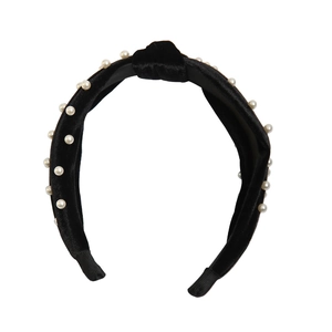 Detailed view of black velvet knot headband with elegant white pearl embellishments