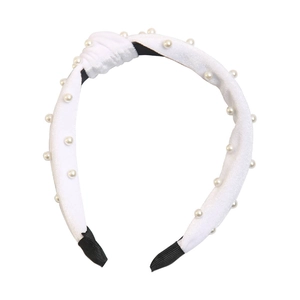 Close-up of white velvet knot headband featuring elegant pearl bead embellishments