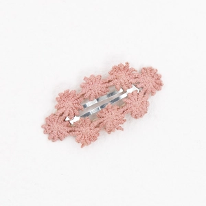 Detail einer Baby-Haarspange mit rosa Häkelblumen und silberner BB-Clip-Basis aus Metall