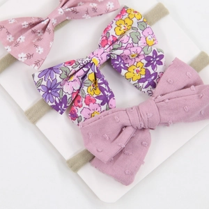 Detail of three floral baby bow headbands with soft elastic nylon straps for infants