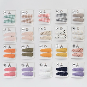 Detailed view of 20 pairs of colorful embroidered and checkered fabric BB hair clips for kids