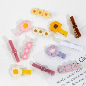 Détail de pinces à cheveux marguerite brodées et de nœuds en velours avec clips en métal