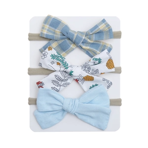 Detailed view of 3-piece floral and blue bow headband set on a white display card