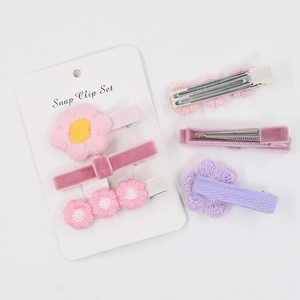 Vue détaillée du lot de 3 barrettes florales avec broderie rose et textures velours
