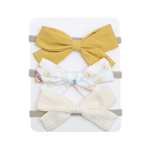 Detailed macro view of three fabric bow headbands with floral and solid patterns