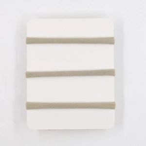 Detailed macro view of three olive green elastic bow headbands on a white display card
