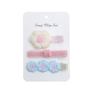 Vue détaillée du lot de trois barrettes à fleurs brodées pour petites filles