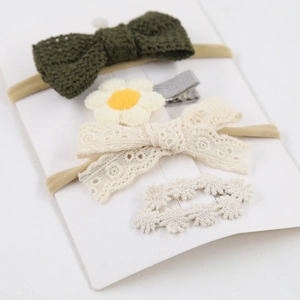 Détail du lot de 4 accessoires cheveux bébé avec nœuds en tricot et fleurs en dentelle