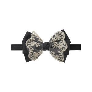 Close-up of black ribbed bow with gold floral lace embroidery and elastic headband