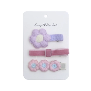 Gros plan d'un lot de 3 barrettes marguerites avec velours rose et broderie violette