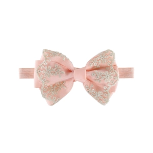Close-up of pink layered bow headband with delicate lace floral embroidery for baby girls