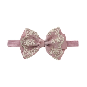 Detailed view of pink grosgrain bow baby headband with beige lace and floral embroidery