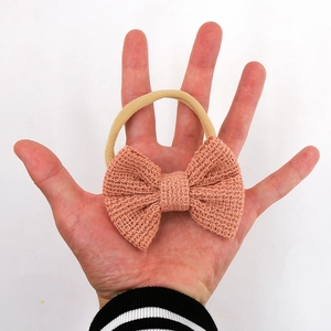 Detail der Textur der pfirsichfarbenen Baumwoll-Strickschleife auf weichem Baby Stirnband