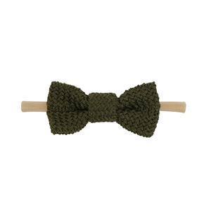 Close-up of olive green knitted cotton bow on soft nylon elastic headband for infants