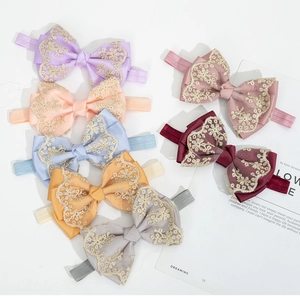 Set of seven colorful baby lace bow headbands with floral embroidery on white stone background