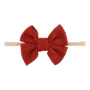 Detail eines roten gestrickten Baby-Stirnbandes mit hochelastischem Nylonband-Makrotextur