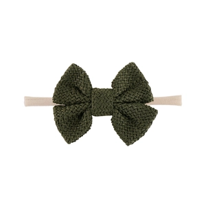 Detailaufnahme einer olivgrünen Strickschleife und weichem Nylon-Babystirnband