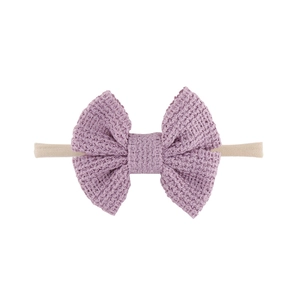 Detailansicht der fliederfarbenen Waffelstrick-Schleife am weichen Nylon-Babystirnband
