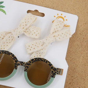 Détail de lunettes de soleil léopard pour enfants et pinces à cheveux en dentelle