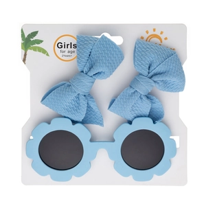Détail des lunettes de soleil fleurs bleu clair et des pinces à nœuds sur carte support