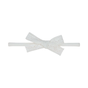 Détail du bandeau bébé avec nœud en dentelle blanche et bande élastique côtelée douce