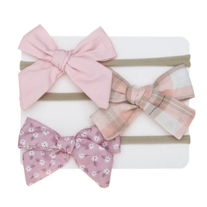 Close-up of three baby headbands with pink, plaid, and floral bows on nylon bands