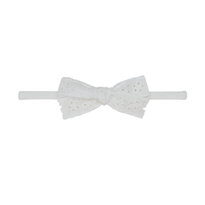 Détail du bandeau à nœud en dentelle blanche avec motif floral et bande en nylon