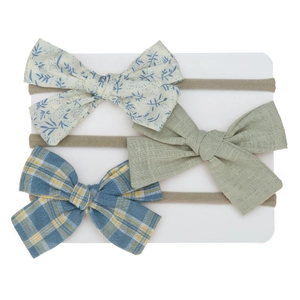 Detailed close-up of three newborn headbands with floral, solid green, and plaid bows
