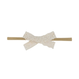 Vue détaillée du bandeau pour bébé avec nœud en dentelle crème et broderies florales